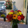 Modern arrangement designed with lilies,  rover mums and roses..just to name