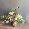 Nestled in a woven basket, this graceful and airy arrangement features beautiful