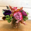A petite arrangement of lavender roses and purple lisi with lavender crysanthemums