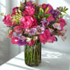 Bursting with energy and charm, this arrangement showcases bold fuchsia roses paired