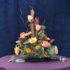A mix of fall colored flowers and greenery in a low design