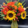 This colorful fall design includes Sunflower, Gerbera daisies, Roses, daisies and Seasonal