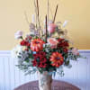 Adorned with orange pumpkin picks and arranged in a delightfully rustic birch