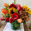 An enchanting display of sunflowers, ranunculus, mums and tulips. 