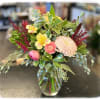 This arrangement has peach ranunculus, alstroemeria, Leucadendron &amp; red astilbe.
