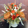 Fall toned flowers mixed with wispy woodland accents designed low. 