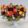 This vibrant fall arrangment is designed in a stone urn with a