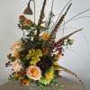 A grasslands concoction of pods, feathers and flowers reminiscent of native florals.