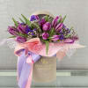 This chic beige box overflows with fresh purple tulips, lavender sprigs, and