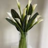 Graceful white calla lilies arranged with simplicity and style. This timeless design