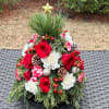 This beautiful tree-shaped arrangement made with fresh greens, red roses, and festive