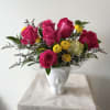 Hot pink roses with some yellow and purple fillers in a white