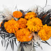 A Mono-bloom arrangement featuring vibrant Marigolds, with preserved pampas &amp; foliage to