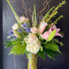 A fragrant arrangement with pink roses, lilles, and blues in a cluster-style