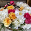 This arrangement includes roses, hydrangeas ,and other seasonal blooms. This is a