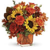 Sunny sunflowers and radiant roses in a happy orange cube vase bring