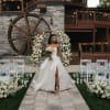 A stunning wedding ceremony setup featuring twin floral arches overflowing with white