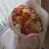 A vibrant blend of fiery ranunculus, peach roses, creamy hydrangeas, and playful