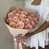 A fresh and elegant wrapped bouquet of roses with soft pink petals