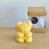 A handmade teddy bear candle crafted from delicate rose-shaped wax details. Perfect