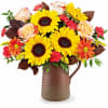 Featuring cheerful sunflowers, rich warm fall tones, this stunning seasonal bouquet sits