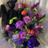 Assorted seasonal blooms in a witches cauldron and lights.