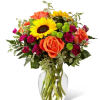 Stunning sunflowers are masterfully woven together with other brightly hued blooms to