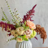 A fall-inspired arrangement in neutral colors. Designed in a ceramic bubble vase.