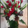 By integrating the elegant Calla Lillie, Red Roses, show stopping Amaryllis, pine-cones