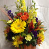 A keepsake pumpkin with snapdragons, gerbra daisies, fall mums and leaves.