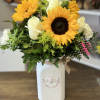 Sunflowers mixed with different color stems arranged in a  keepsake vase.