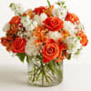Loosely gathered inside a clear cylinder vase, the mix of vibrant orange