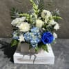 White roses, chrysanthemums, snapdragon, hydrangea, with other filler blooms, and foliage. 