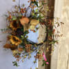 A wreath decorated in warm tones with autumn leaves and sunflowers