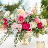elegant container fill with palette of pink seasonal flowers .