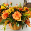 Ceramic pumpkin container full of beautiful autumn flowers