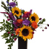 This elegant vase arrangement of sunflowers, roses &amp; carnations will warm up