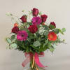 A colorful and happy mix of red roses and multicolored gerbera daisies.

