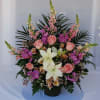 A traditional pastel arrangement of snapdragons, stocks, roses, astromelias, and lilies.