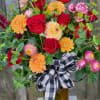A fall colored vase filled with autumn colors in a lovely display!