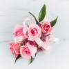 Pink rose corsage with ribbon and small purple flowers
