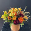 A fall inspired arrangement with roses, mini carnations, cushion sprays, solidago and