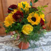 Beautiful vased arrangement with fall flowers. Golds, burgundy, yellows, and seasonal greenery.