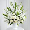 Create an elegant and tranquil atmosphere with our all-white funeral arrangement, featuring