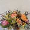 Lots of Local Greenery, Proteas and other accents in a birch container.