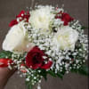 This bouquet features white and red roses with babys breath.