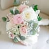 This bouquet features pastel pink and white roses with babys breath. 