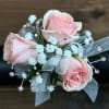 Pastel pink roses on a wristlet with babys breath. Accented with gems