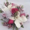 This corsage features hot pink spray roses and white dendrobium Orchids. This