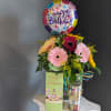 A dozen Gerbera Daisy paired with fun birthday items. 